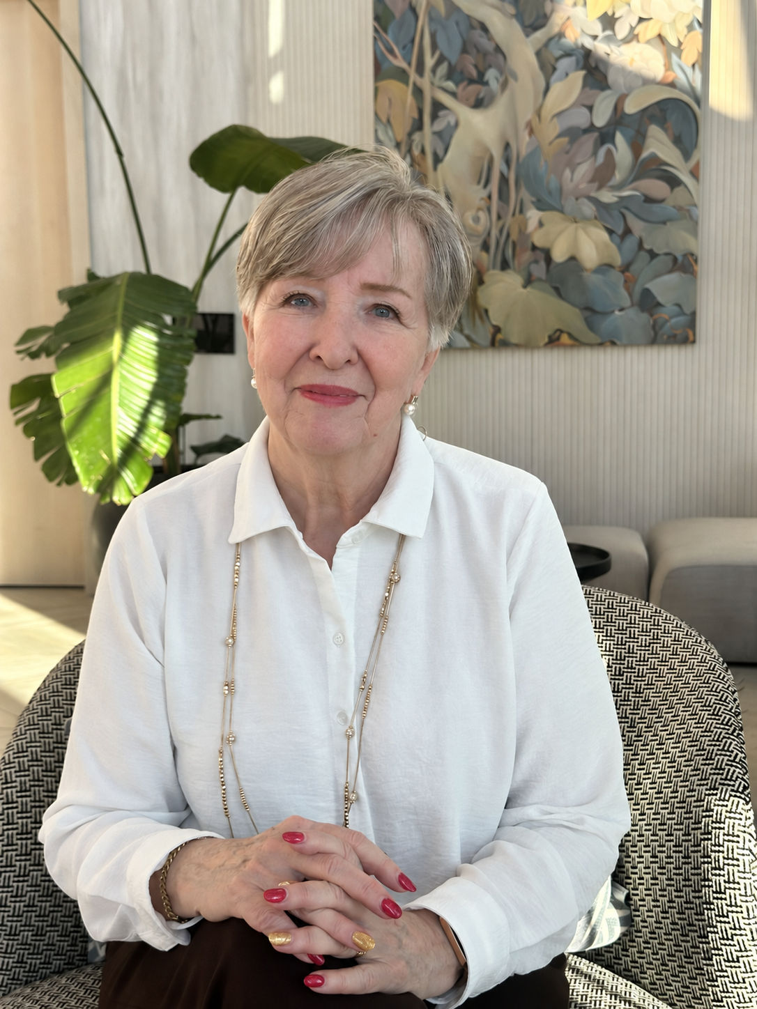 Janice Wheeler seated at home in a white blouse